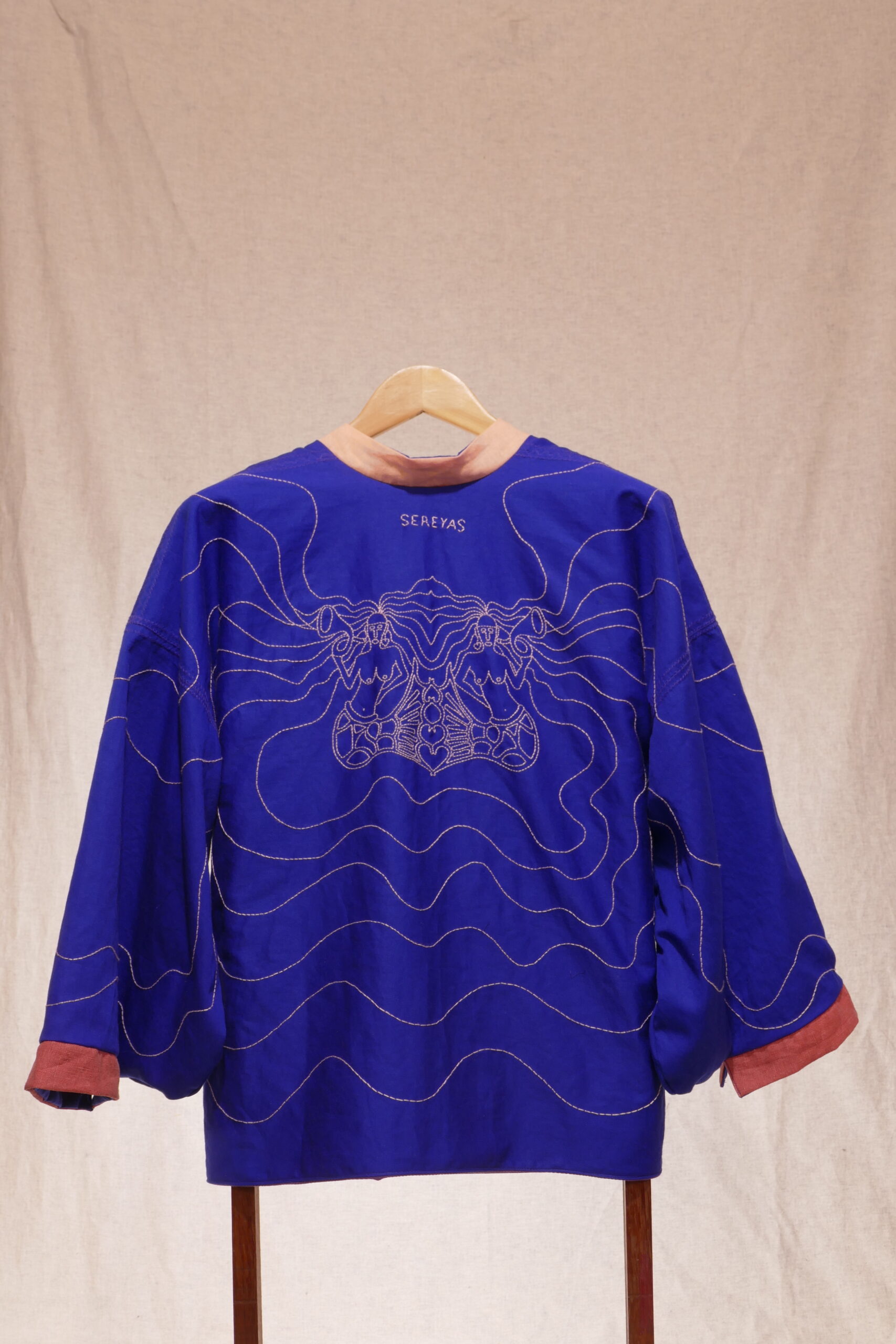 SEREYAS. 2019-2021. Linho e algodão bordado. 70cmx152cmx7cm. Kimono frente e verso com um lado azul com aplicação de bordado livre feito a mão e do outro lado mistura de tecidos nos tons de rosa. [1707X2560 px]