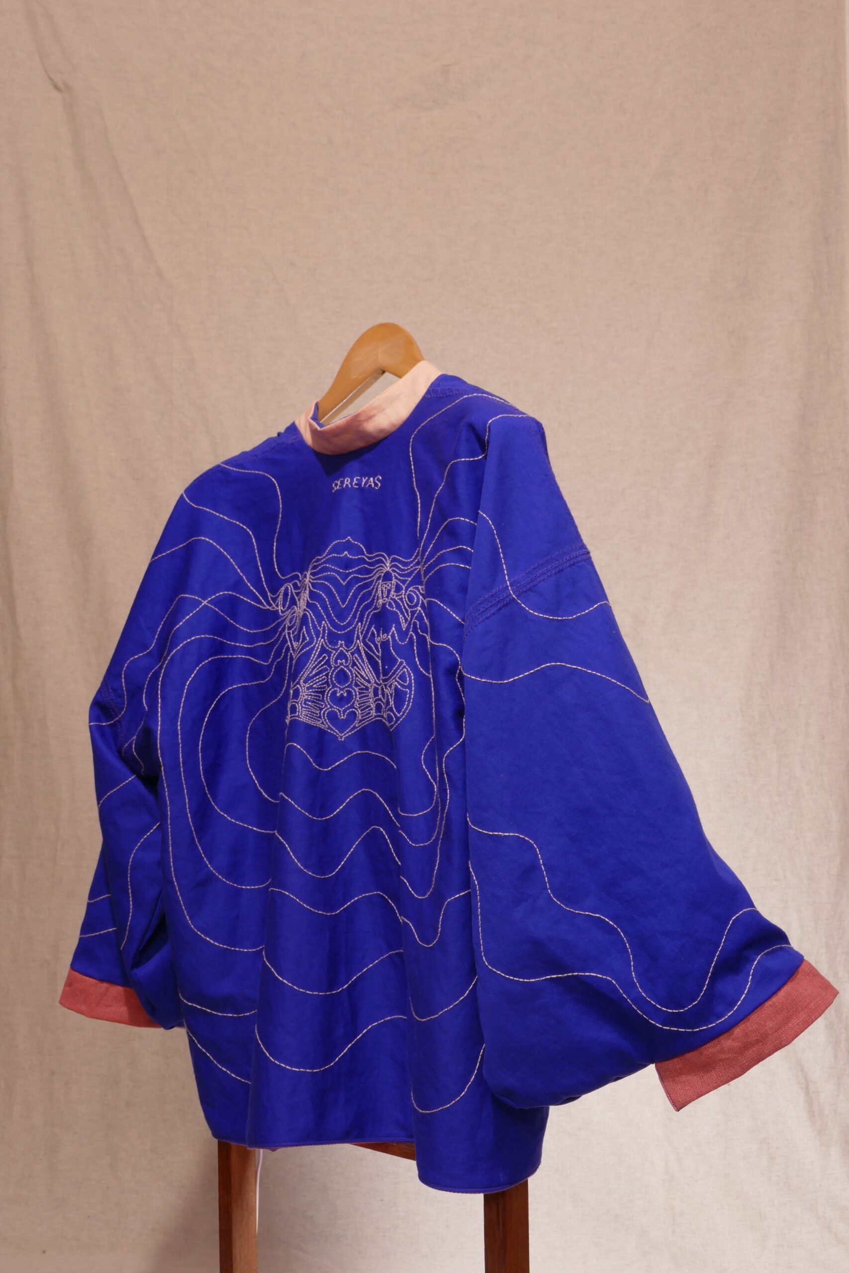 SEREYAS. 2019-2021. Linho e algodão bordado. 70cmx152cmx7cm. Kimono frente e verso com um lado azul com aplicação de bordado livre feito a mão e do outro lado mistura de tecidos nos tons de rosa. [1707X2560 px]