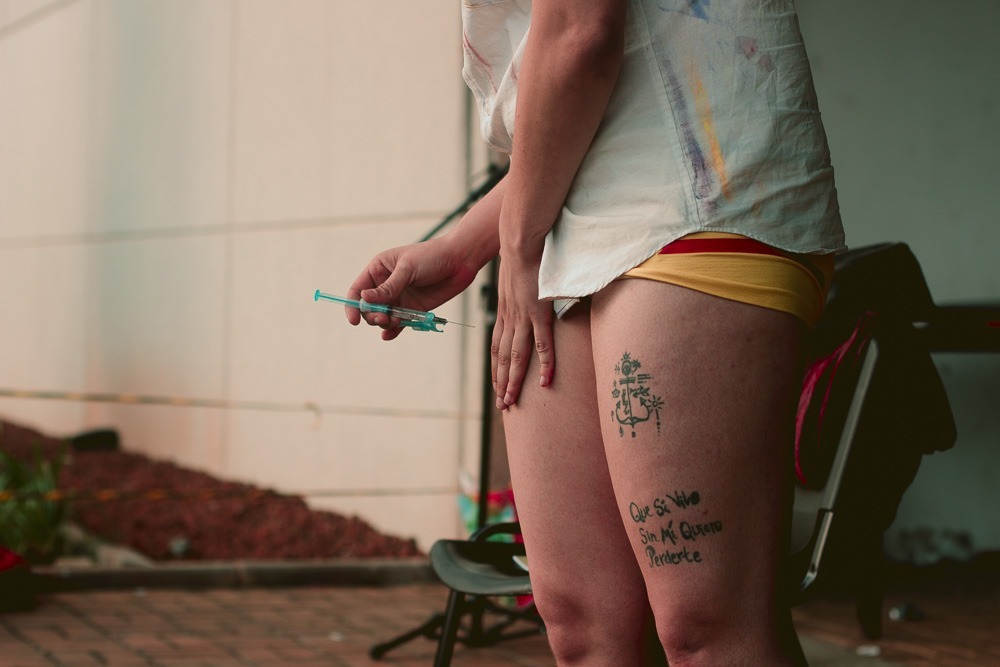 Performance T – Outra Porta, 2017. Registro em foto por Gabrielo.
A performance de autoaplicação de Testosterona em público é uma pesquisa que completa 4 anos em abril de 2021, mesmo tempo desde o início de minha transição hormonal. Visibilidade e possibilidade de intervenção no cis.tema são os motores dessa ação. A autoaplicação enquanto um movimento de autofazer-se. [100x667px]